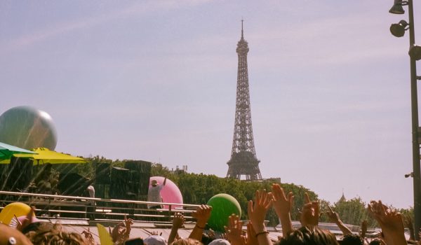 Folla a un festival di musica elettronica a Parigi con la Tour Eiffel sullo sfondo durante la Fete de la Musique.